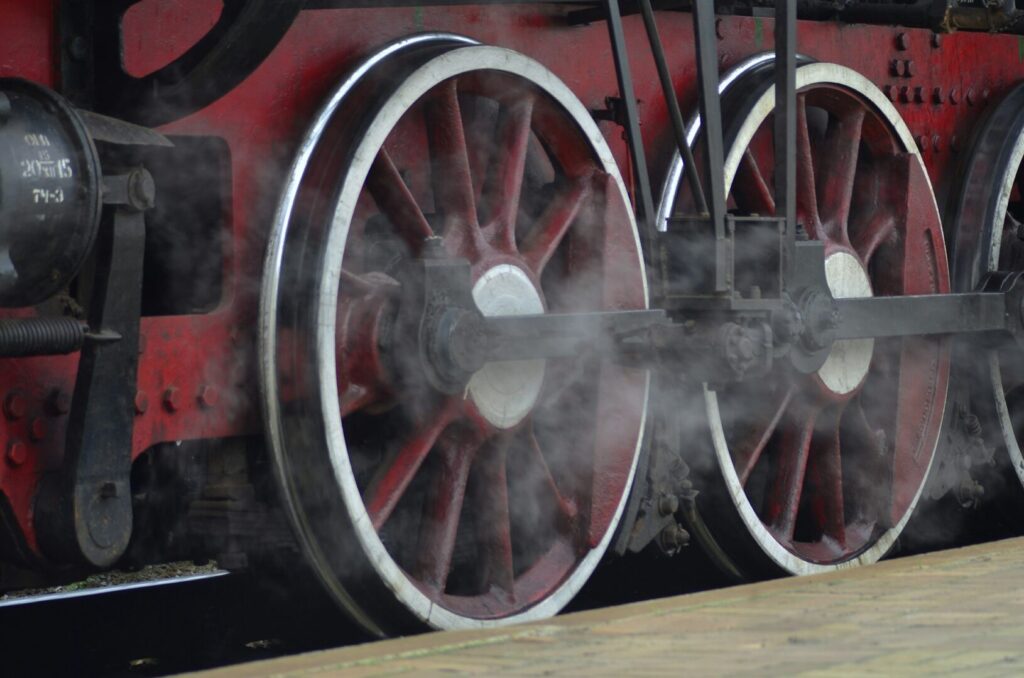 Red wheels of old USSR black steam locomotive. Wheels of an old soviet steam train